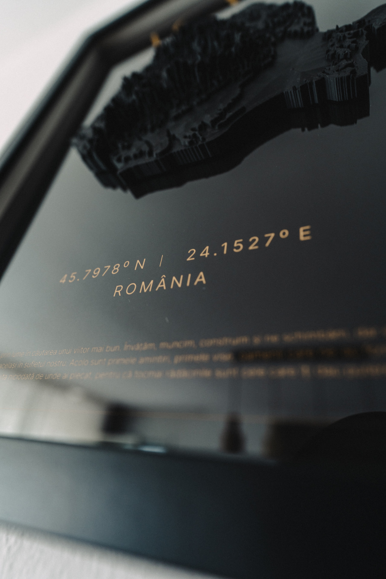 Gold coordinates and country lettering detail